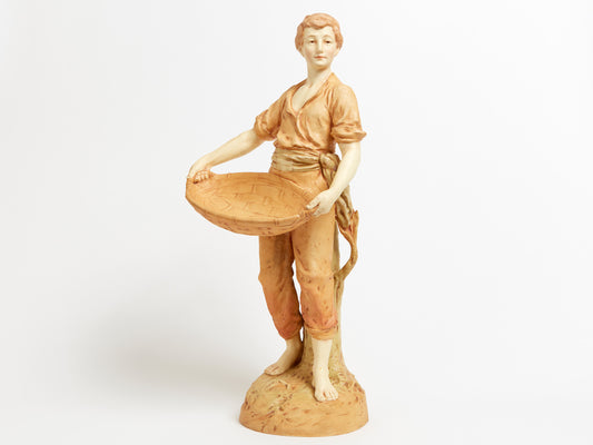 A HANDSOME AUSTRIAN PORCELAIN FIGURE OF A MAN WITH A BASKET, IN THE MANNER OF ROYAL DUX.