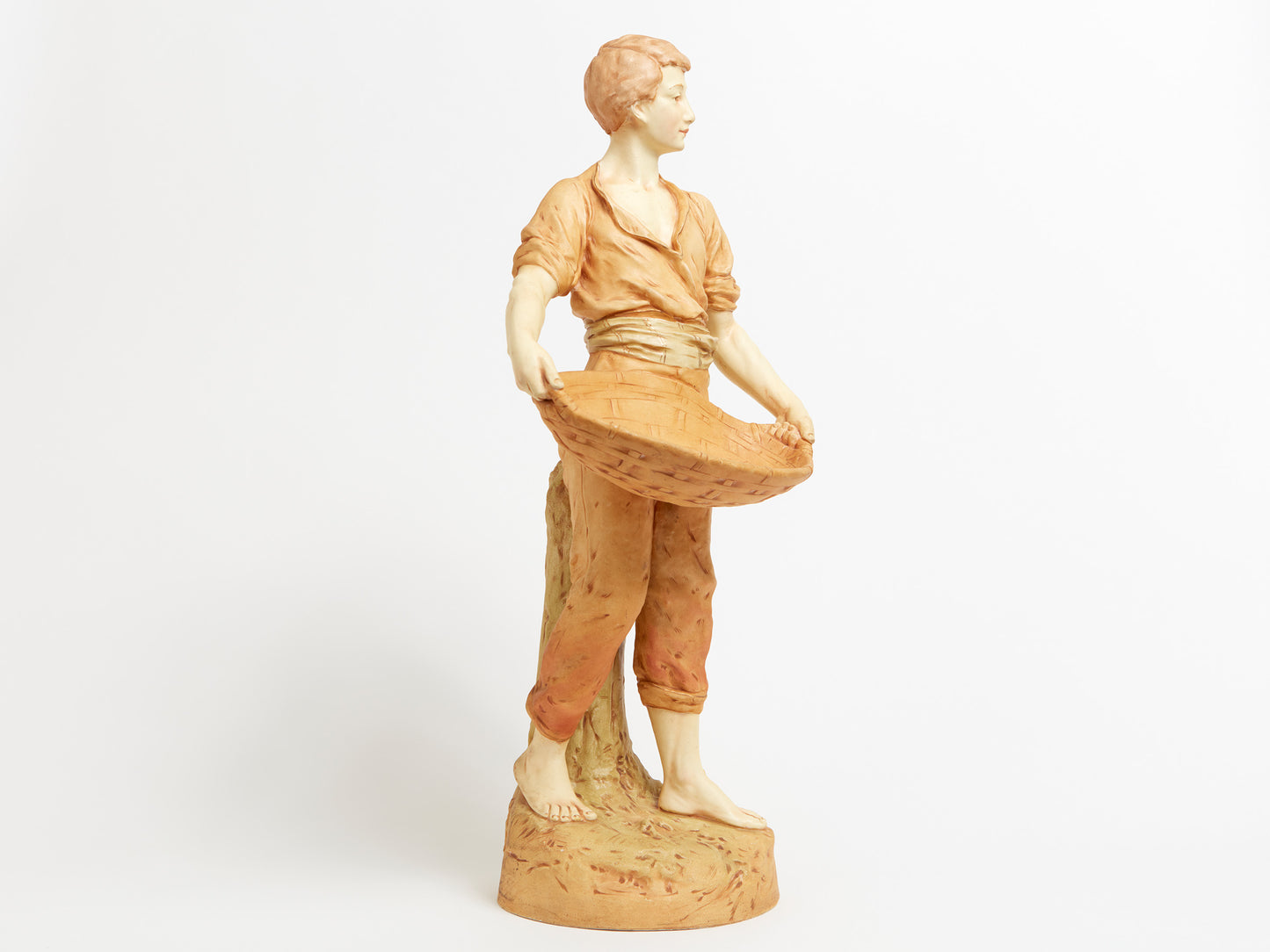 A HANDSOME AUSTRIAN PORCELAIN FIGURE OF A MAN WITH A BASKET, IN THE MANNER OF ROYAL DUX.