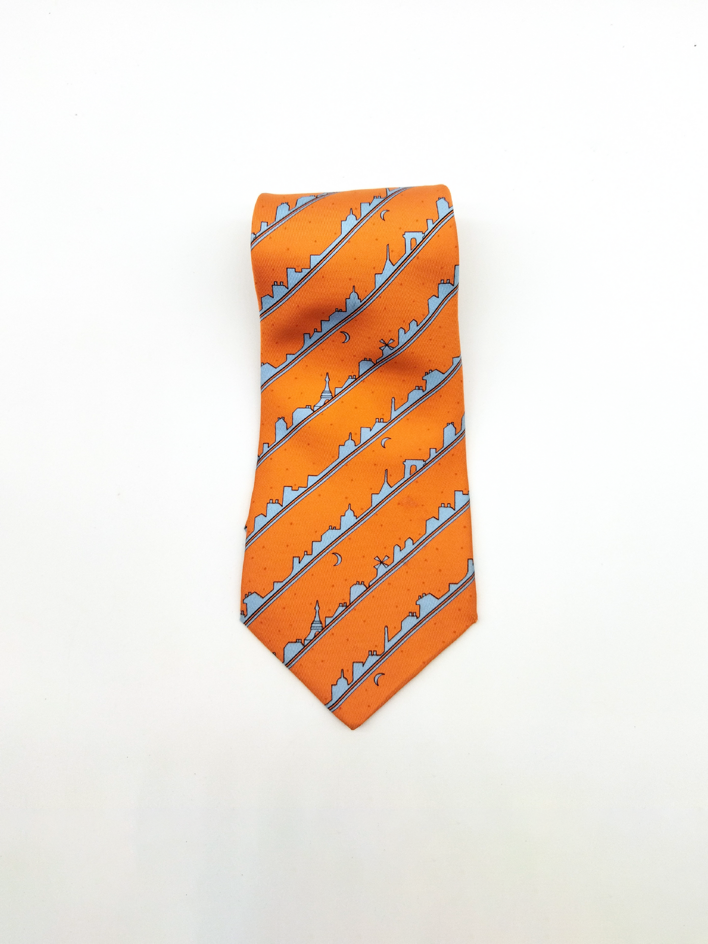 HERMÈS SILK TIE, ORANGE WITH PARIS SKYLINE PATTERN.