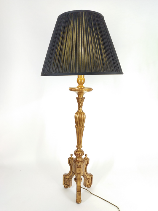 AN ANTIQUE STYLE  GILT-WOOD CANDLESTICK TABLE LAMP WITH PLEATED BLACK SHADED, TOTAL HEIGHT 110cm.