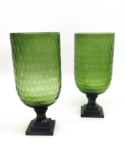 A PAIR OF HEXAGONAL PATTERN GREEN GLASS HURRICANE LAMPS WITH SQUARE BASE.