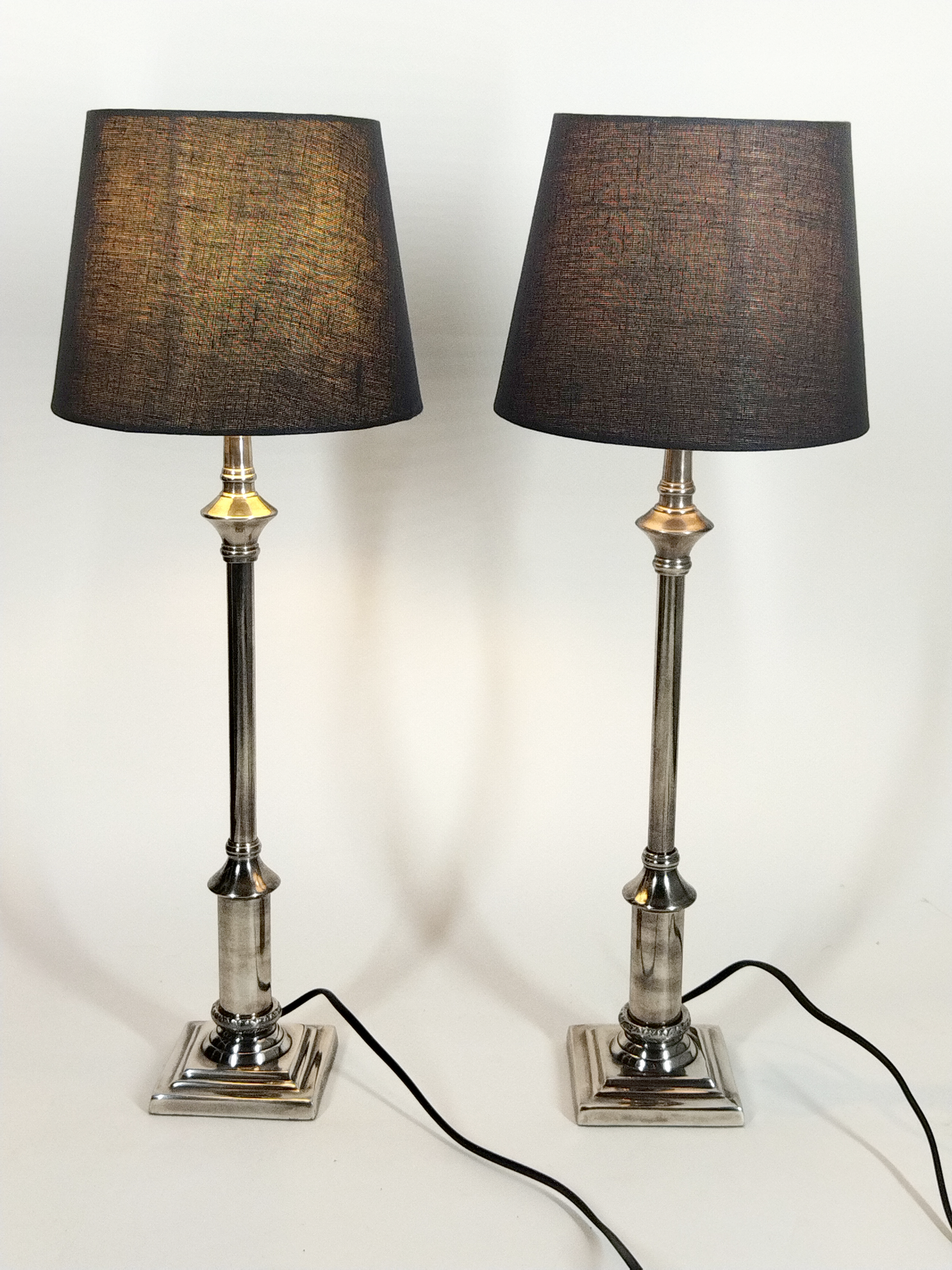 A PAIR OF SILVER-TONE TABLE LAMPS TO A SQUARE BASE AND BLACK TAPERED SHADES, TOTAL HEIGHT 58cm.