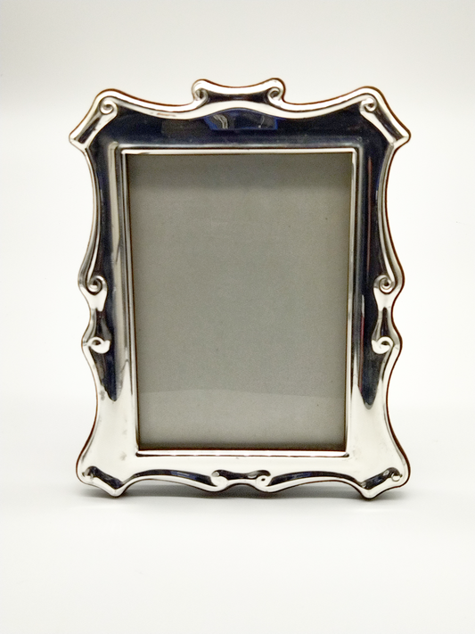 A SILVER PLATED FRAME WITH SCROLL FORM DETAIL, 14 x 10cm.