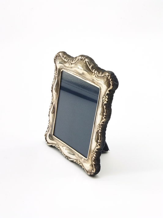 A STERLING SILVER FRAME WITH FANCY EDGE DETAIL HALLMARKED LONDON 1991, 14 x 10cm.