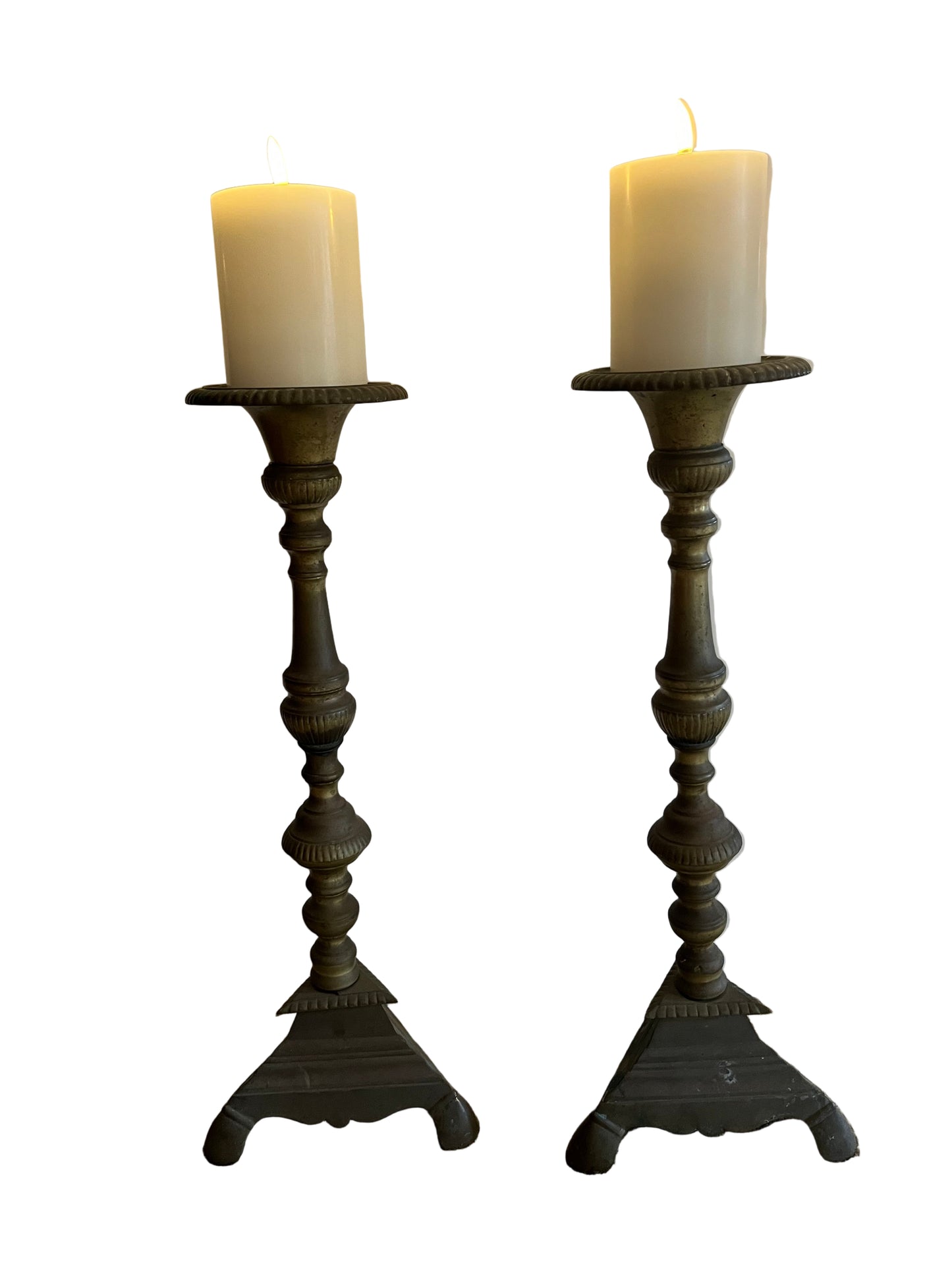 A PAIR OF TALL BRASS CHURCH CANDLESTICKS, HEIGHT 50cm, WITH UYUNI FLAMELESS PILLAR CANDLES.
