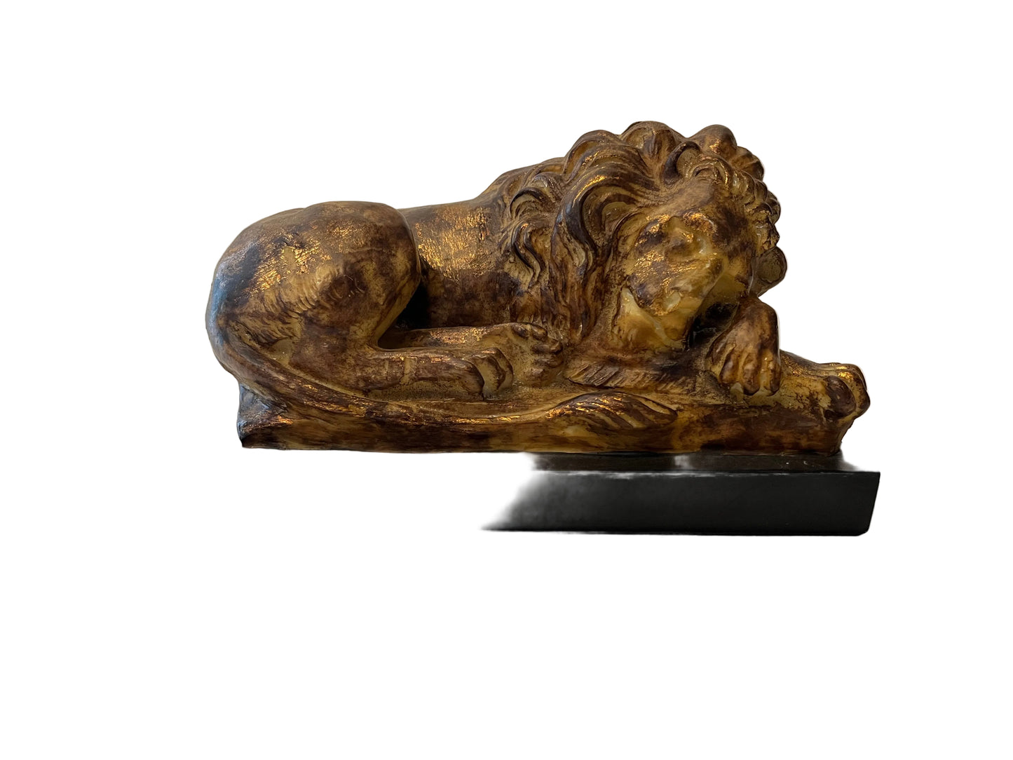 A COMPOSITE SLEEPING LION SCULPTURE IN A GILDED FINISH, TO A MARBLE BASE.
